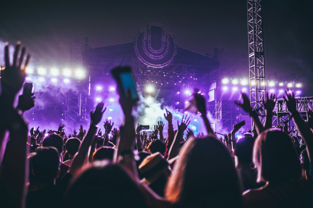 People raise their hands in the air at a rock concert