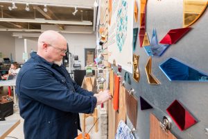 A professor arranges some of the items in the Materials Library