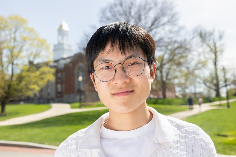 Andy Zhang poses in front of the Wilbur Cross building