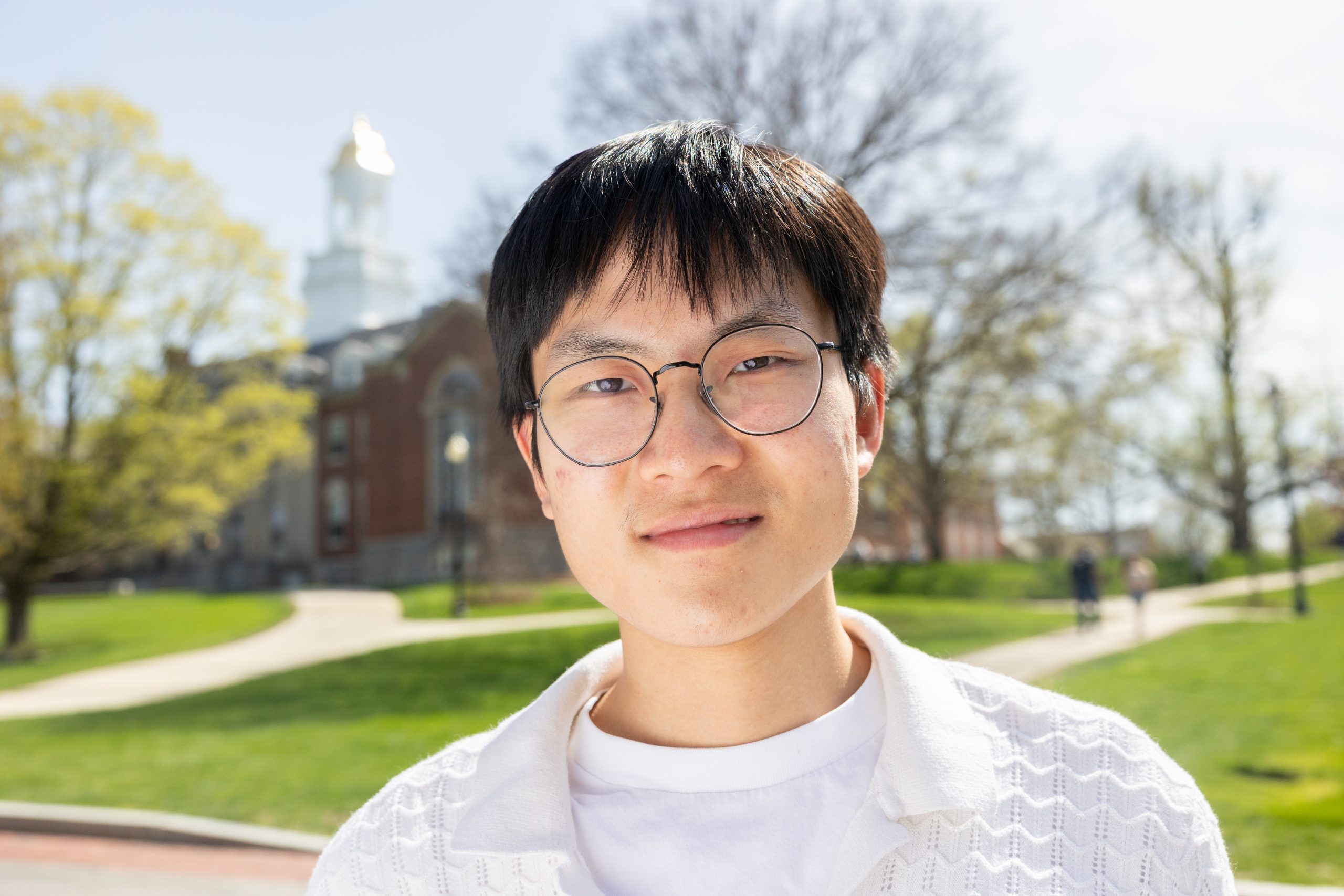 Andy Zhang poses in front of the Wilbur Cross building