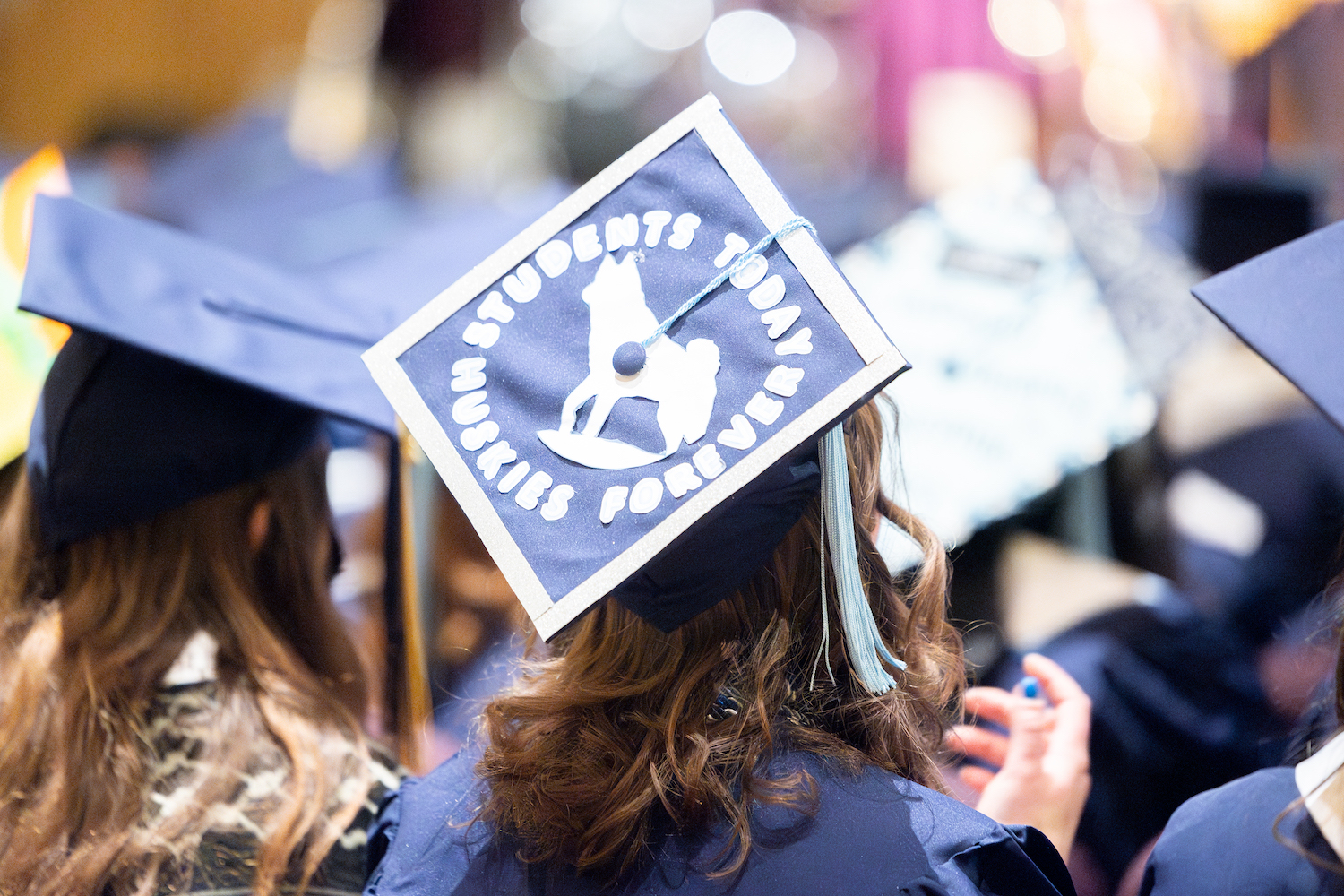 Grad cap with a husky logo on it with "students today, huskies forever"