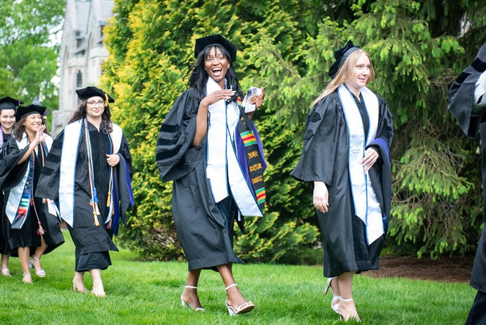 A graduate strikes a pose while processing.