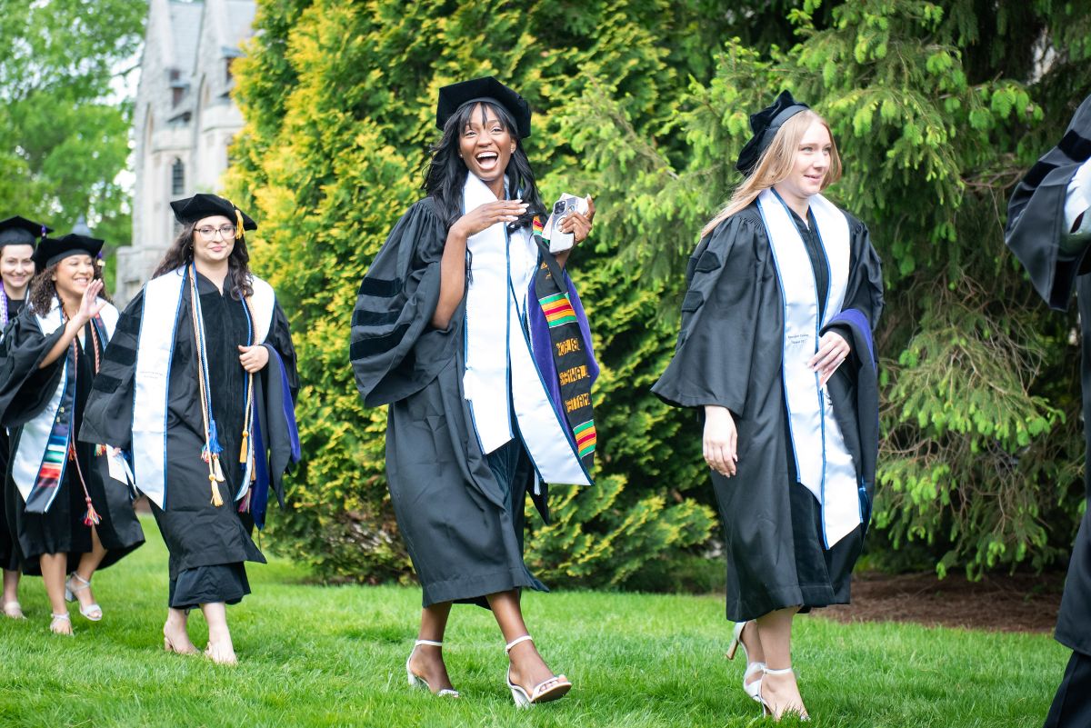 A graduate strikes a pose while processing.