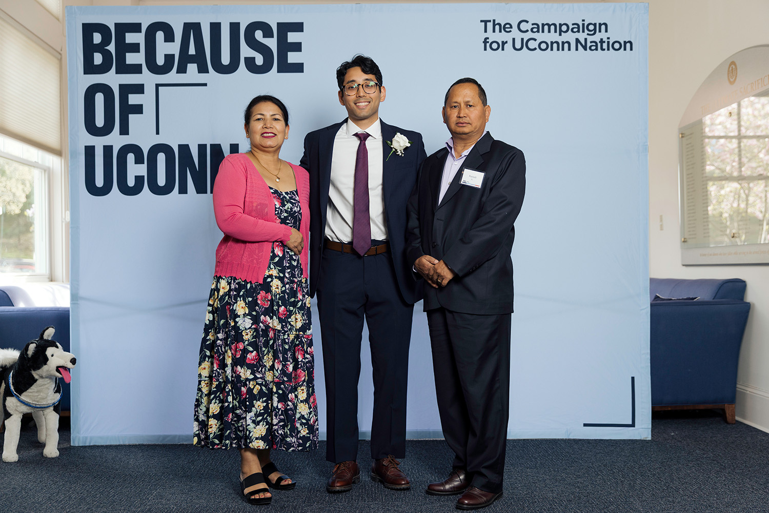 Prabhas KC ’22 (CLAS) and family stand in front of a backdrop that reads "The Campaign for UConn Nation."