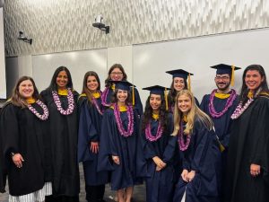 Students in caps and gowns posing for a picture