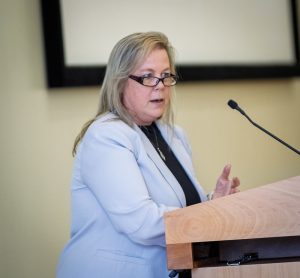 Erika Lindberg, at podium during Academy induction ceremony