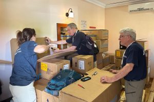 Three people looking through boxes of medical supplies