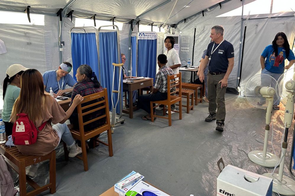 candid shot of inside of tent clinic triaging patients