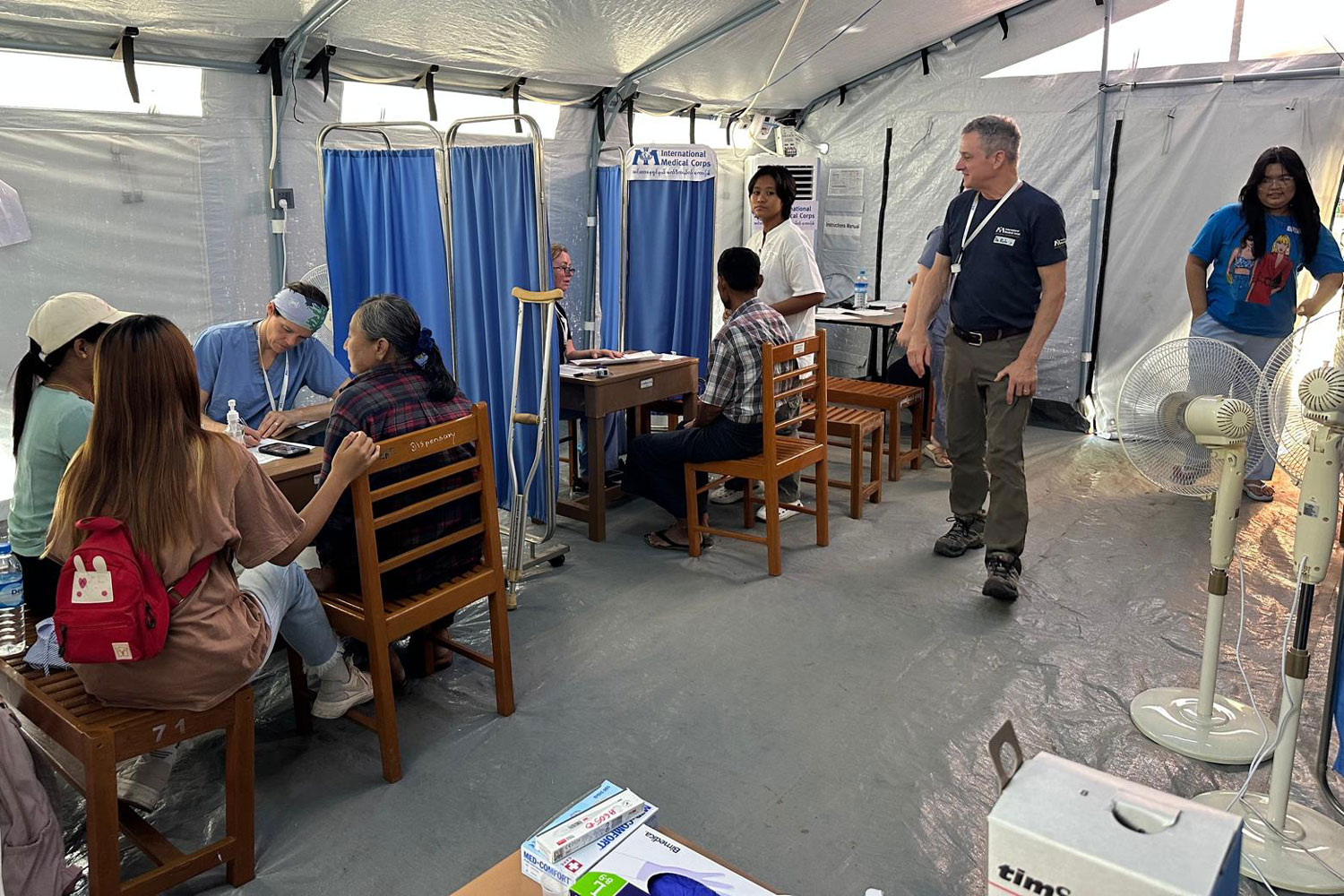 candid shot of inside of tent clinic triaging patients