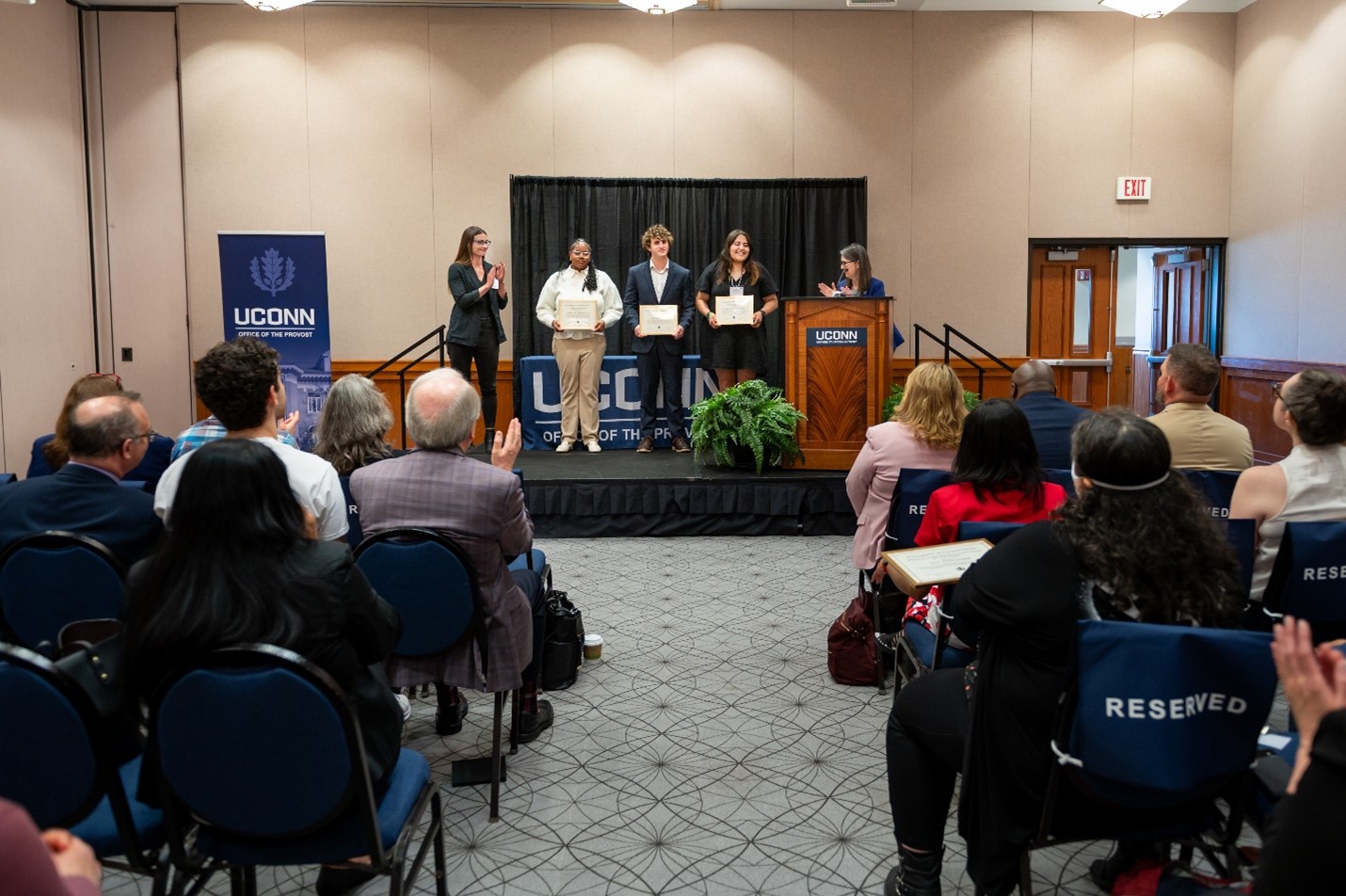 An audience watches as people on a stage are given awards.