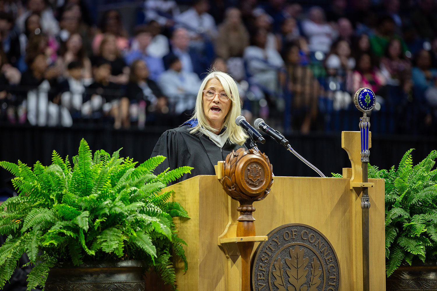 Maureen Ahern ’85 (CLAS) stands behind podium at Gampel Pavilion.