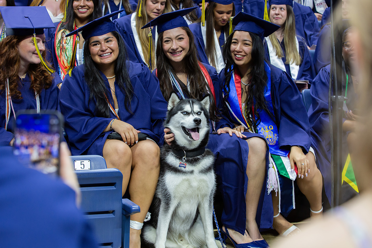 Jonathan XV sits with graduates in Gampel Pavilion.