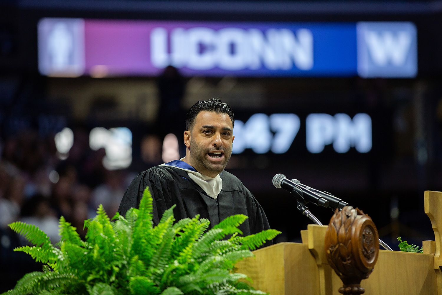 Joe La Puma ’05 (CLAS) stands behind podium in Gampel Pavilion.