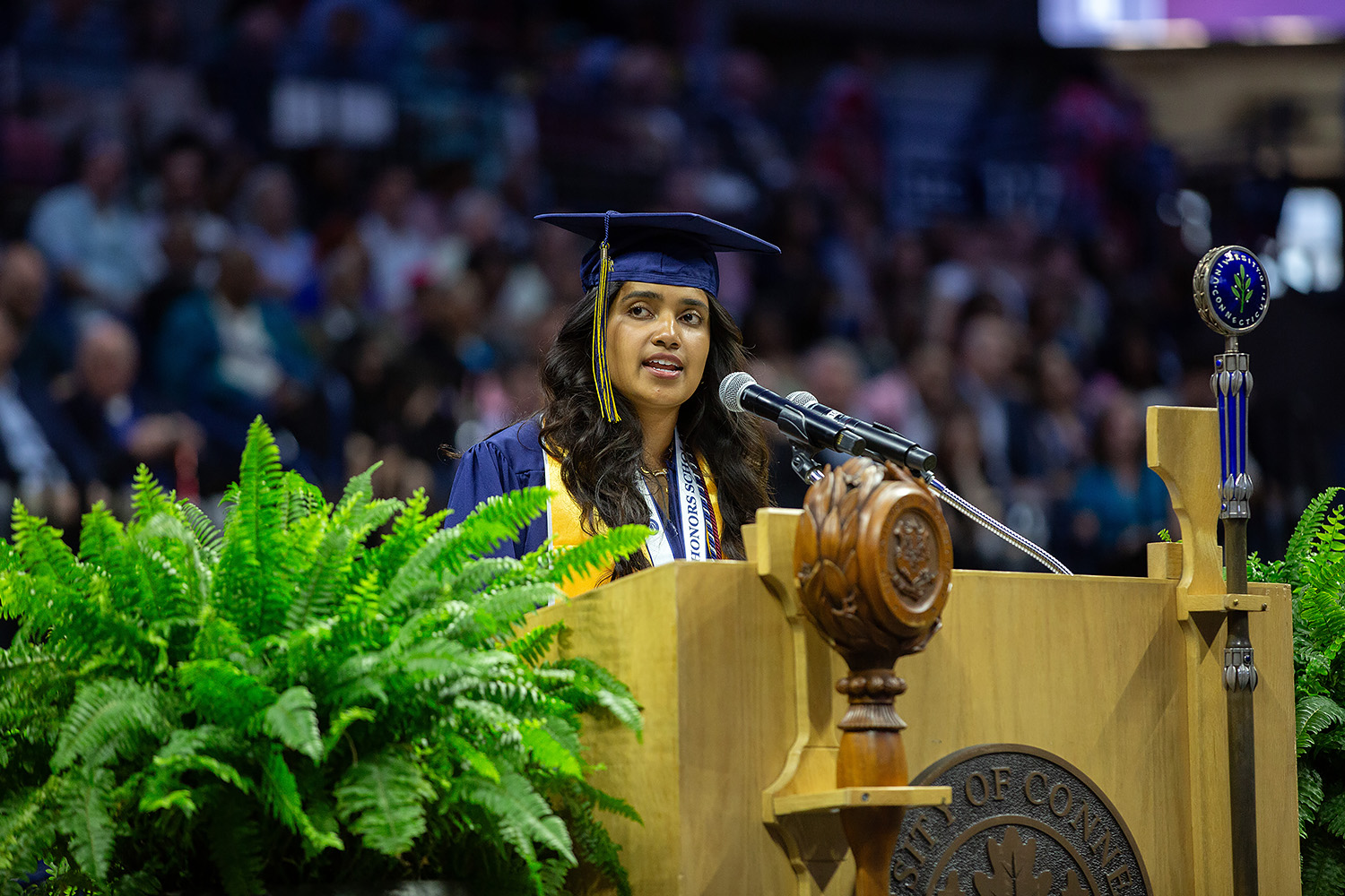 Aishwarya Benzy ’25 (CLAS) stands behind podium in Gampel Pavilion.