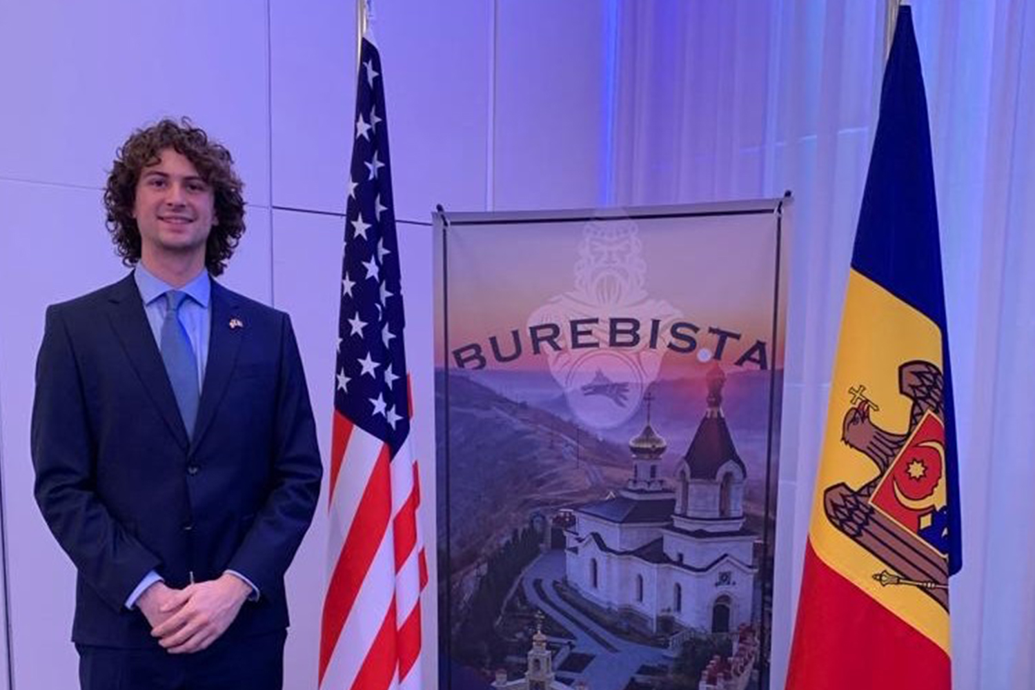 A boy standing next to a U.S. and Germany flag