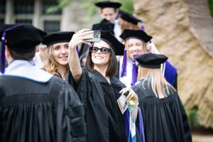 A graduate takes a group selfie
