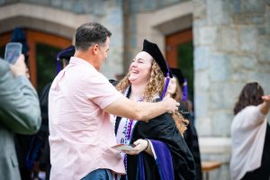 A graduate celebrates with another person