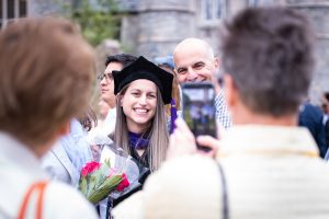 A graduate smiles as someone takes her photo.