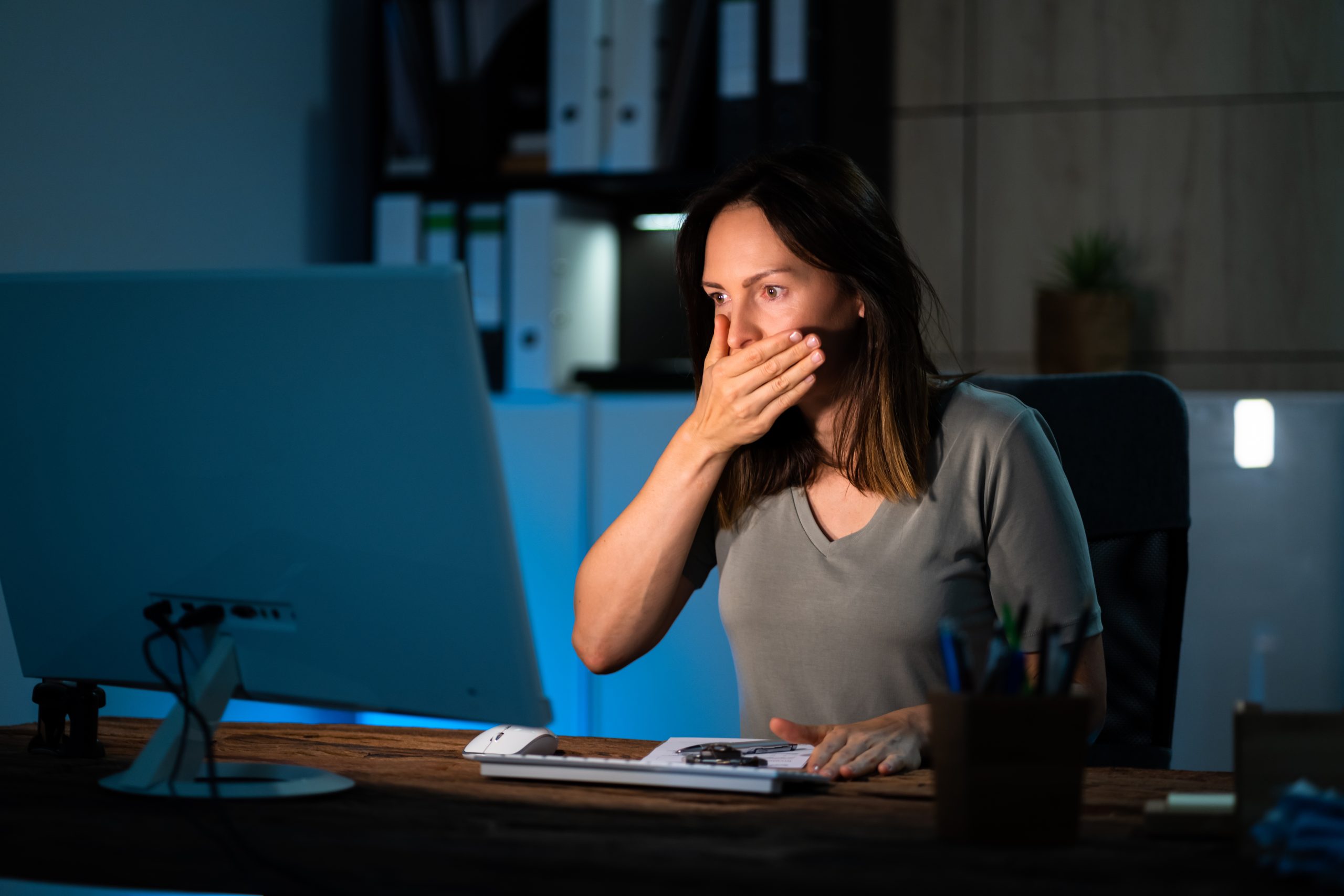 A woman gasps at her computer screen.