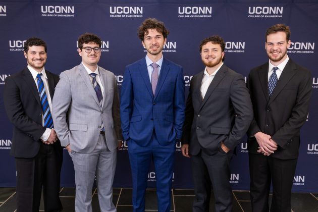 Five men in suits smiling and posing in front of a UConn College of Engineering backdrop.