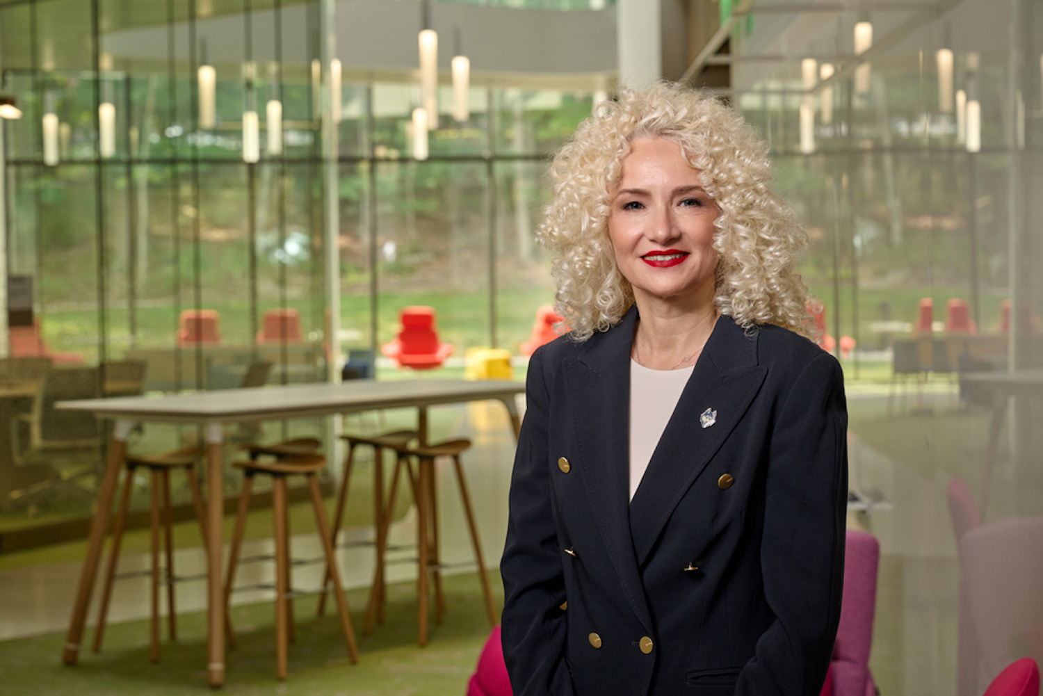 Portrait of UConn President Radenka Maric in front of a table and a glass wall