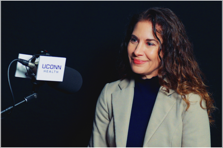 Dr. Rebecca Andrews in studio by UConn Health microphone