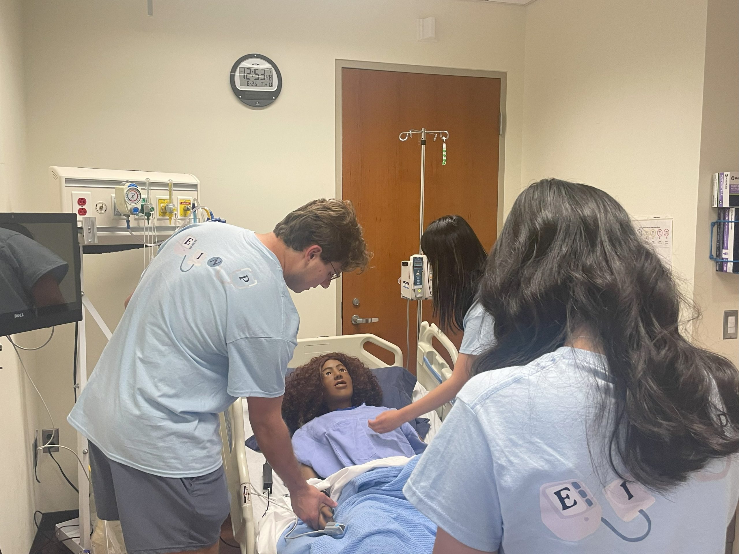 High school students in the Early Introduction to the Nursing Profession (EINP) program taking pulses on a full-size cardiopulmonary simulator mannequin on June 26, 2025. (Aime Liggett/UConn Photo)
