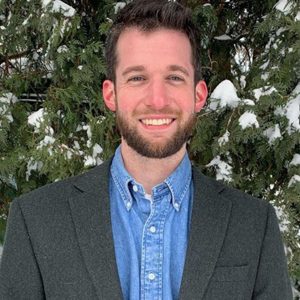 Portrait of a man with a blue shirt and suit jacket