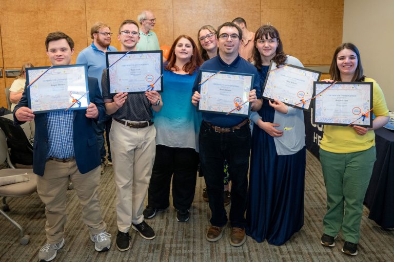 group portrait of seven, five holding certificates