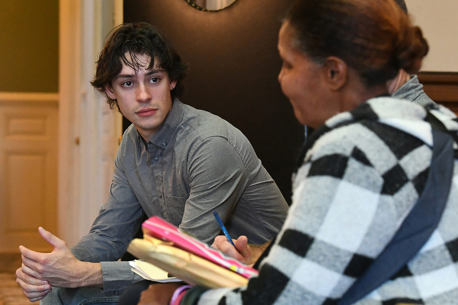 A student listens intently while another person speaks at an eviction court hearing.
