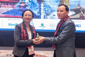 Man handing award to Anu Maharjan