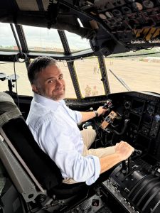 UConn MBA program Team member Mike Bozzi sits in a USAF airplane cockpit.
