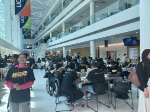 Students sitting around round tables inside the UConn Stamford campus building