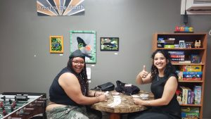 Two women playing a board game at a table.