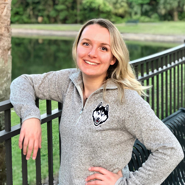 elizabeth-hintz-fulbright_UCTedit A woman in a gray sweatshirt standing by a fence