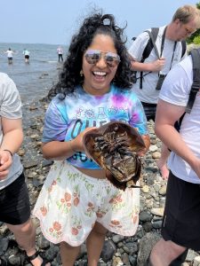 Student smiling and holding a horseshoe crab