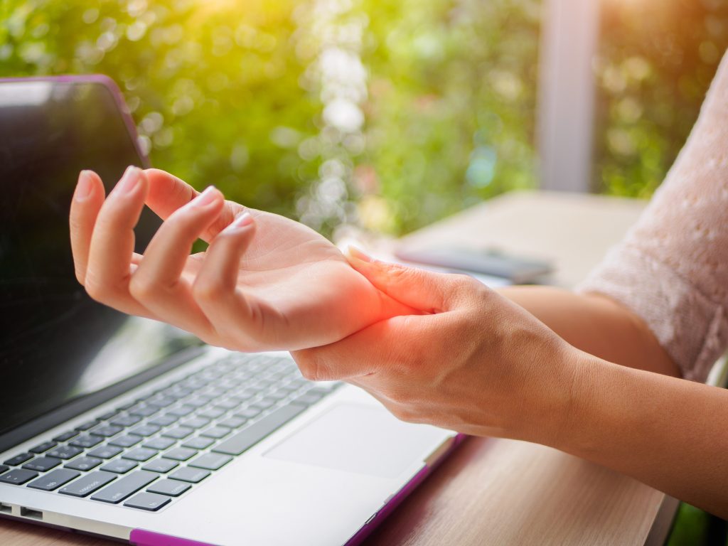 Adobe Stock image of woman hand pain at computer.