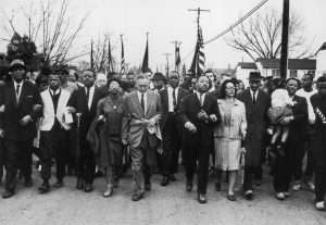 A historical photo of Martin Luther King Jr. and other civil rights protesters during a march in 1965.