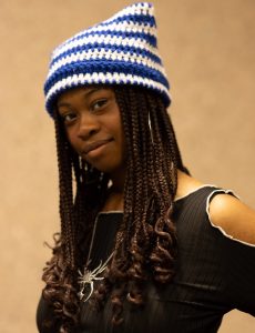 Photo of a woman with long black hair wearing a blue and white striped beanie