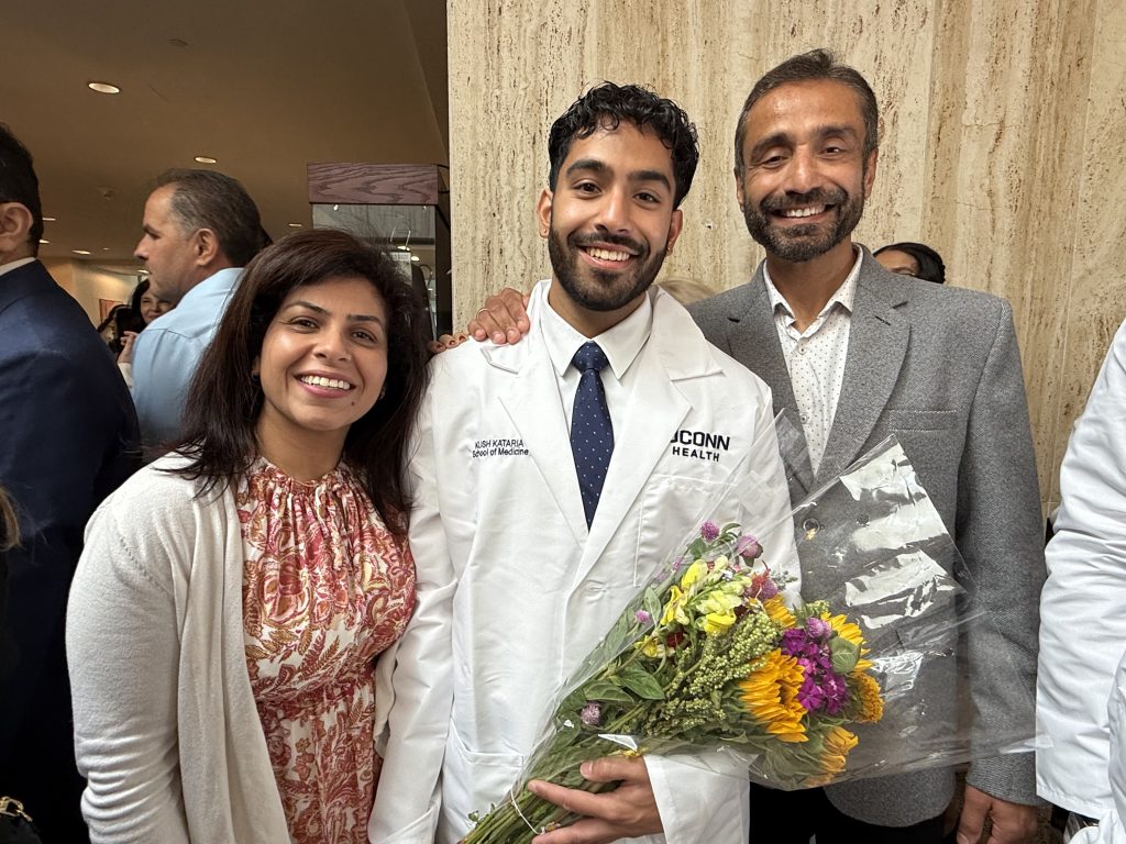 The future Dr. Kush Kataria celebrating with his white coat with his parents (Lauren Woods/UConn Photo).