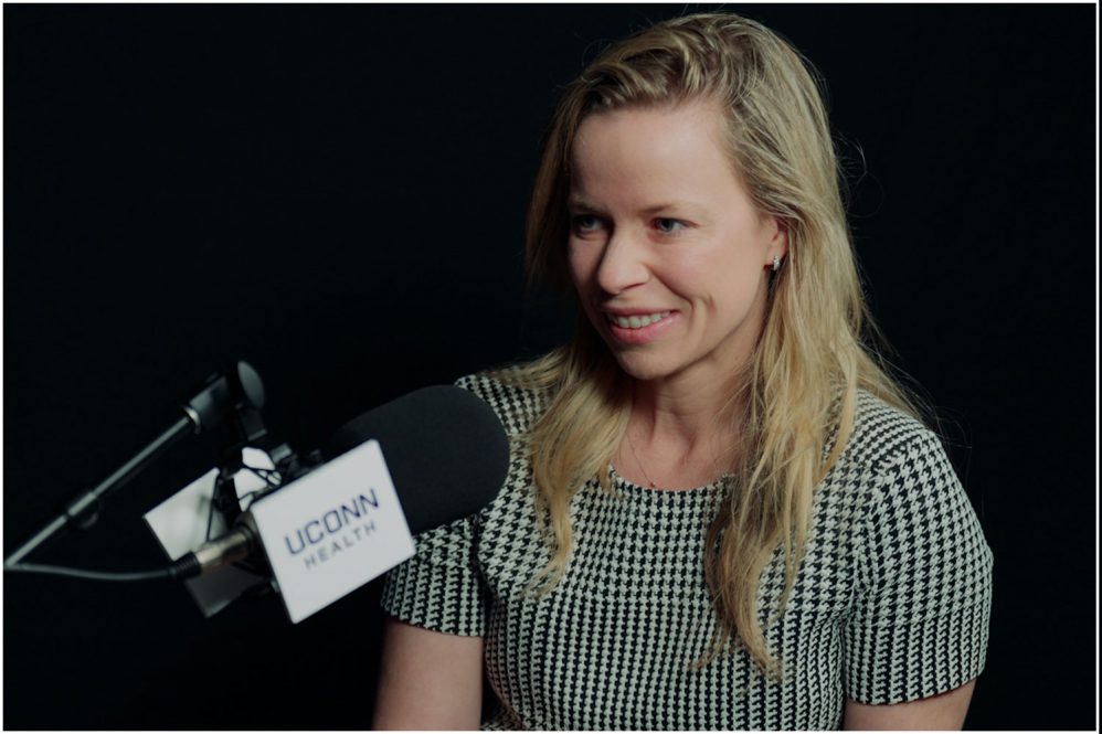 Dr. Jenna Kelsey at podcast microphone
