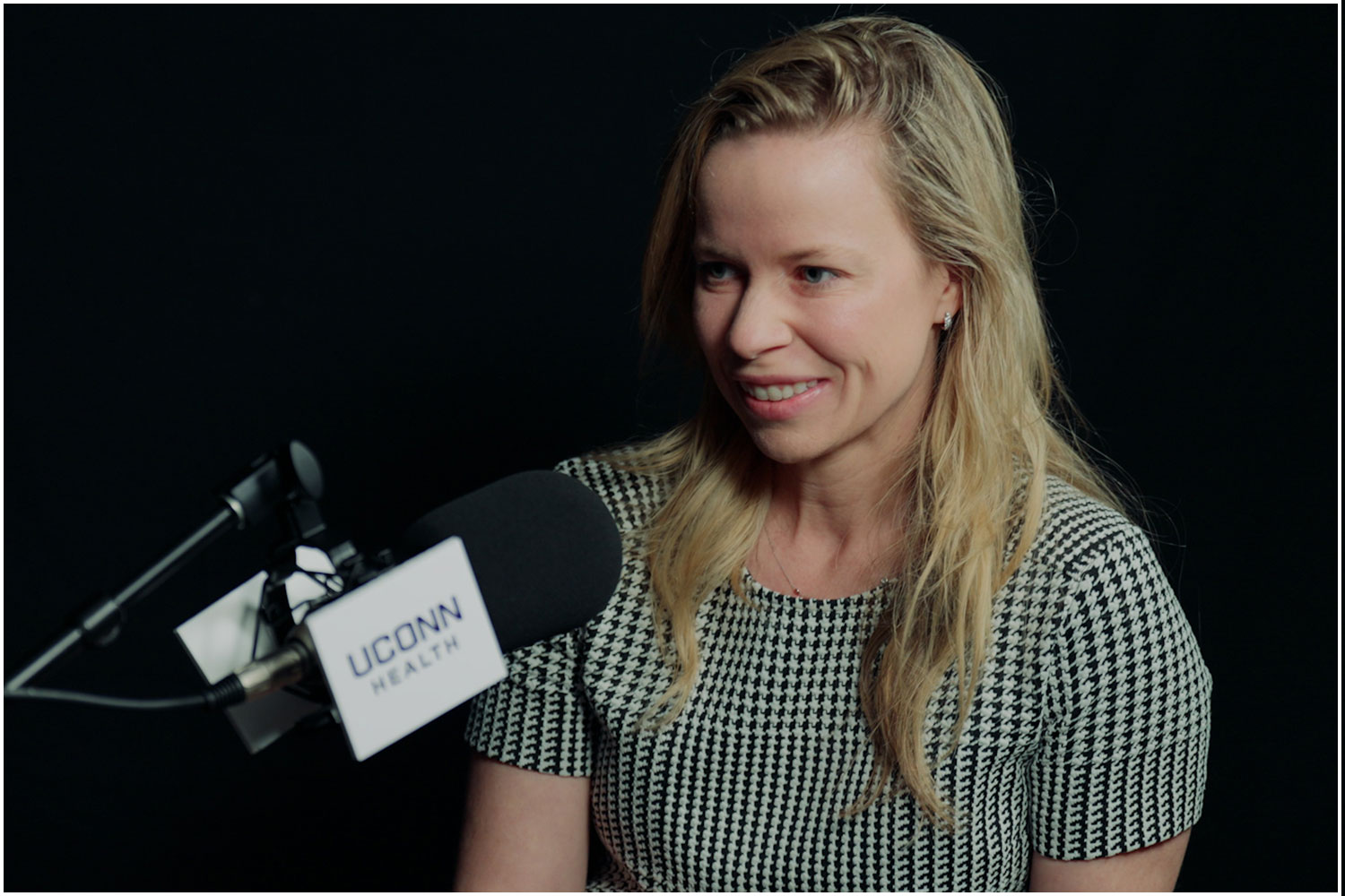 Dr. Jenna Kelsey at podcast microphone