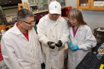 Three College of Engineering researchers examine a water sensor in their lab at UConn.