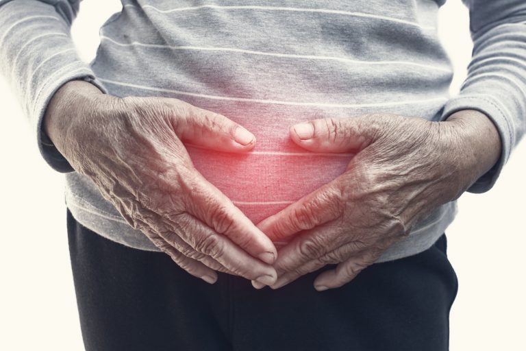 Older woman holding stomach area.