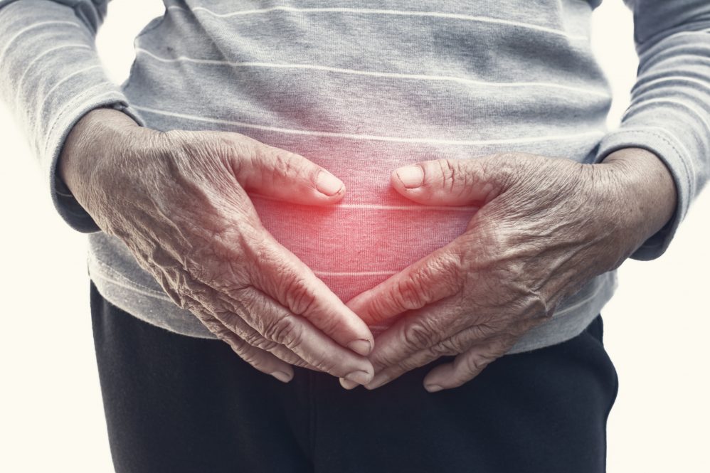 Older woman holding stomach area.