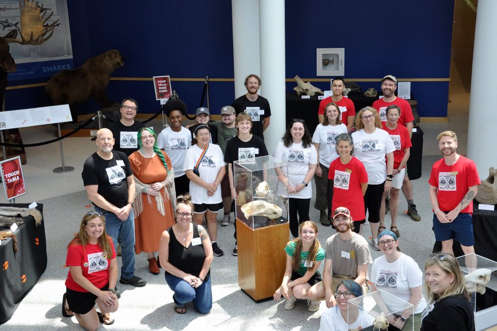 A group photo with dozens of volunteers wearing Connecticut State Museum of Natural History T-shirts.