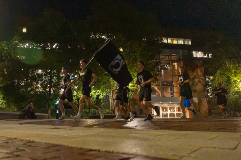 UConn Air Force and Army ROTC cadets carry the POW/MIA flag around campus