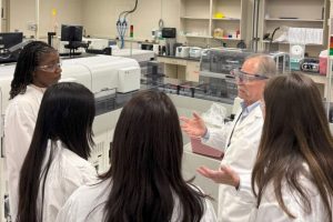 Dr. Sidney Hopfer in conversation with a group of students in the UConn Health lab