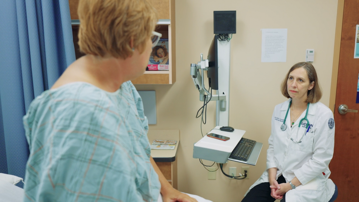 Dr. Darlene Oksanen, primary care physician, uses an AI transcription tool on a cell phone to aid in note taking during a patient exam.