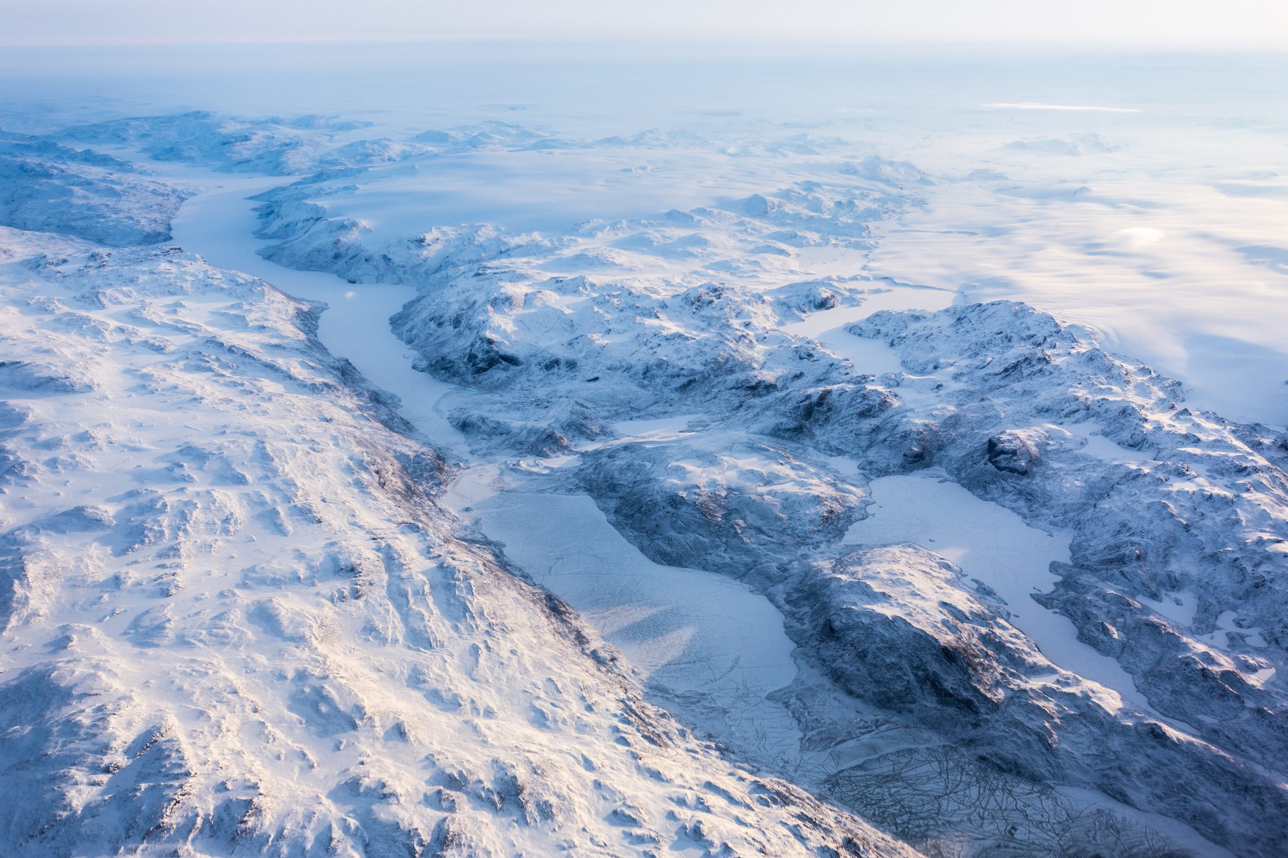 Greenlandic ice cap with frozen mountains and fjord aerial view
